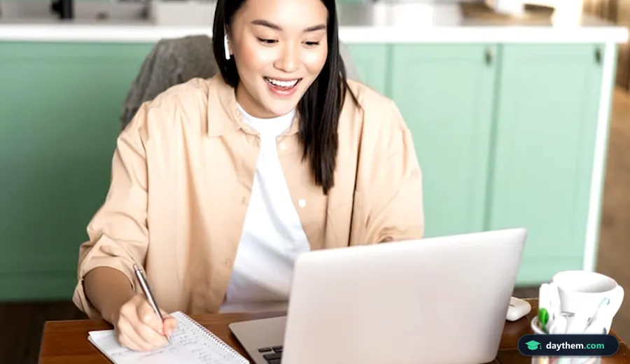Học viên nữ ghi chép khi tham gia lớp học tin học trực tuyến qua laptop tại nhà