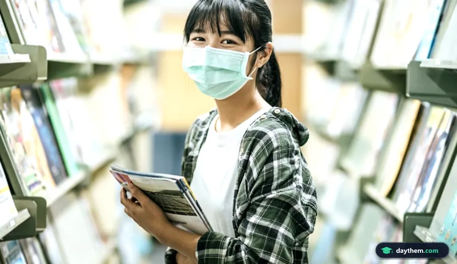 Sinh viên đang tìm kiếm tài liệu và nghiên cứu sách trong thư viện.